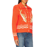 Person wearing an orange sweater with a white pattern